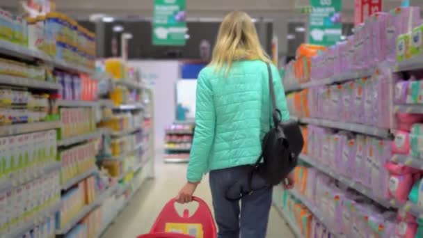 Young Slender Blonde Walks Department Supermarket Studying Prices Looking Goods — 图库视频影像