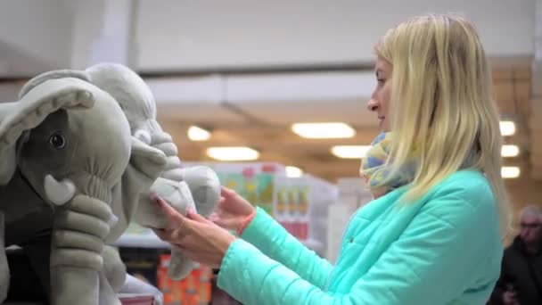 Μαγαζί Παιχνίδια Αγοραστής Επιλέγει Παιχνίδι Γυναίκα Αγοράζει Αρκουδάκι Ελέφαντα Ελέφαντα — Αρχείο Βίντεο
