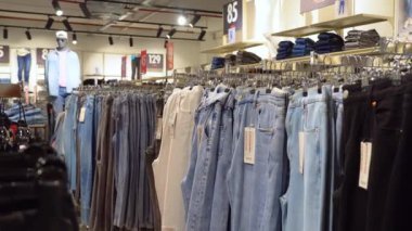 BATUMI, GEORGIA - 26 Mayıs 2022: elbise mağazasında askıda asılı kot pantolon veya Denim pantolonu. Moda ürün koleksiyonu satış için giyim mağazasında. Tekstil endüstrisi ve iş konsepti