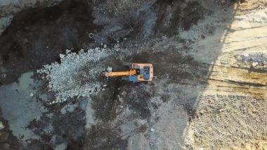 İnşaat alanında büyük sarı kazıcı ya da buldozer var. Kamera çarptı, İHA 'yı hareket ettir. - Evet. İnşaat alanı. İnşaat. Ağır makineler