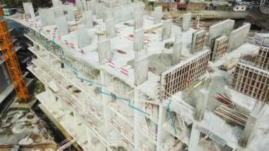 Yüksek inşaat alanı. Arka planda mavi gökyüzü ve şehir manzaralı büyük endüstriyel bir vinç. Beton levhalar ağırlık dengesi. Karşı ağırlık. Hava aracı görüntüsü. Metropolis Şehir Geliştirme