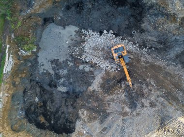 İnşaat alanı, kazıcı ve traktörün drone görüntüsü. Hava fotoğrafçılığı.