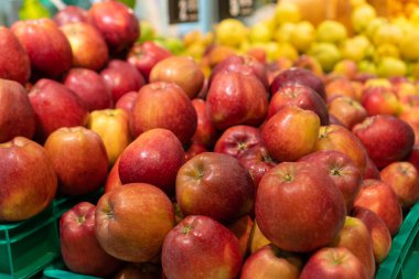 Mağazadaki tezgahın üzerinde lezzetli, olgun kırmızı ve sarı elmalar var. Markette ve süpermarkette meyve satışı