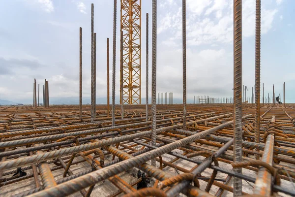 Stacks of square metal and rusty reinforcing rods and mesh for building construction. Reinforcing frame of the base plate. Reinforcing metal frame for pouring concrete on a construction site.