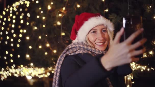 Красивая Блондинка Шляпе Санта Клауса Разговаривает Видео Мобильному Телефону Эмоционально — стоковое видео