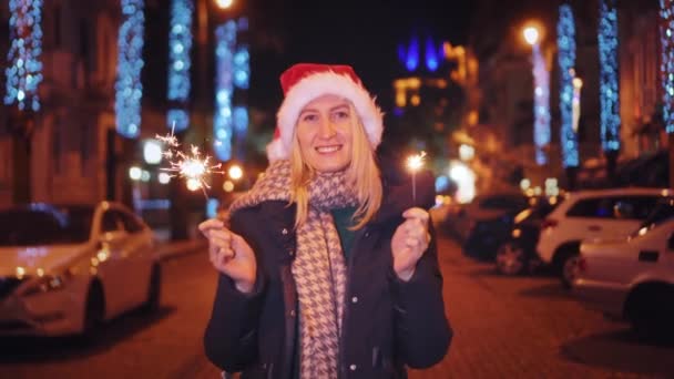 Žena Klobouku Santa Clause Chodí Zimní Noci Ulice Zdobena Věnci — Stock video