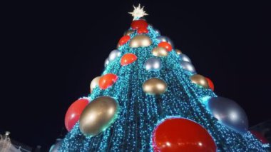 Tatil süslenmiş yeşil Noel ağacı oyuncaklar, renkli toplar, elektrikli çelenkler, ışıl ışıl parlayan ve yanıp sönen. Yeni Yıl ve Xmas Kutlama konsepti, şenlikli atmosfer. Şehrin Gece Sokağında