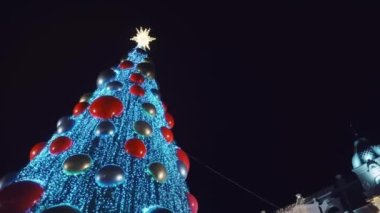 Tatil süslenmiş yeşil Noel ağacı oyuncaklar, renkli toplar, elektrikli çelenkler, ışıl ışıl parlayan ve yanıp sönen. Yeni Yıl ve Xmas Kutlama konsepti, şenlikli atmosfer. Şehrin Gece Sokağında
