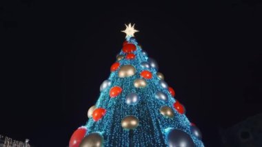 Tatil süslenmiş yeşil Noel ağacı oyuncaklar, renkli toplar, elektrikli çelenkler, ışıl ışıl parlayan ve yanıp sönen. Yeni Yıl ve Xmas Kutlama konsepti, şenlikli atmosfer. Şehrin Gece Sokağında