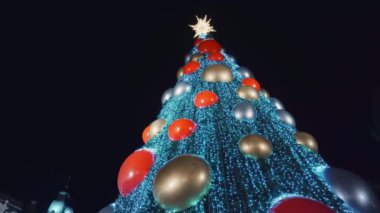 Tatil süslenmiş yeşil Noel ağacı oyuncaklar, renkli toplar, elektrikli çelenkler, ışıl ışıl parlayan ve yanıp sönen. Yeni Yıl ve Xmas Kutlama konsepti, şenlikli atmosfer. Şehrin Gece Sokağında