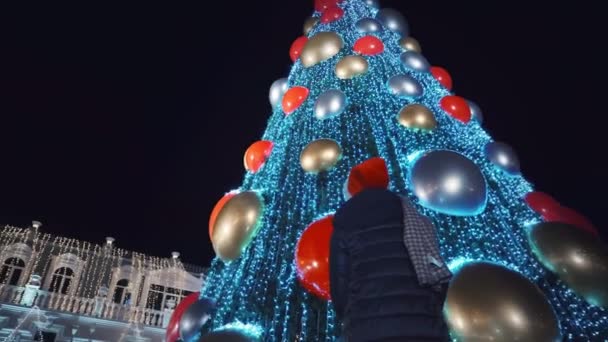 Žena Stojí Zády Kameře Dívá Vysoký Městský Vánoční Stromek Ulici — Stock video