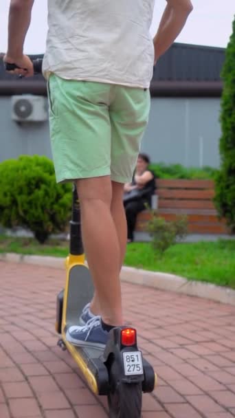 Hombre Joven Camisa Blanca Pantalones Cortos Verdes Monta Scooter Eléctrico — Vídeos de Stock