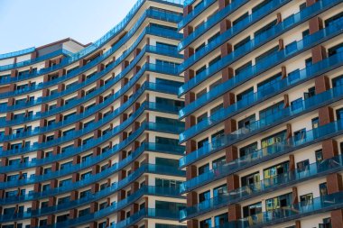 Beautiful modern blue-brown facade of apartments with balconies in the hotel on a sunny day