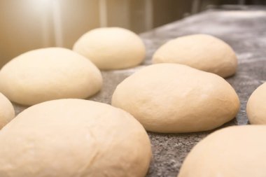 Mutfak masasındaki çörek ya da diğer buğday unları için taze hamur toplarının yakın plan çekimi. Pişirmek için boş. Aydınlatma ile fotoğraf