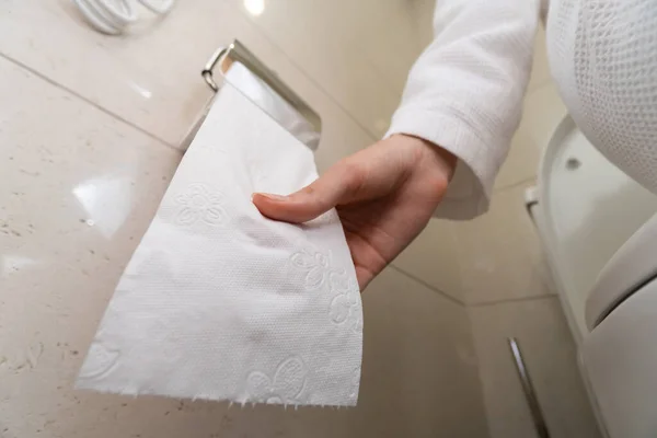 Женщина Белом Халате Сидит Унитазе Тянет Туалетную Бумагу Ванную Селективный — стоковое фото