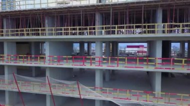 İnşaat alanının insansız hava aracı görüntüsü. İnsansız hava aracı inşaat halindeki çok katlı bir binanın zeminine çıkıyor.