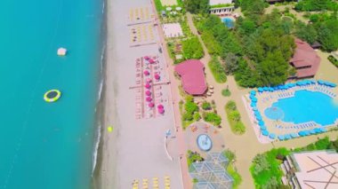 Drone view of a beautiful beach resort with a swimming pool, umbrellas and turquoise sea. Paradise place, Georgia.