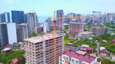 İnşaat alanının insansız hava aracı görüntüsü, inşaat halindeki çok katlı binalar, Gürcistan 'da deniz manzarası ve büyük metropol manzarası. Batum. Gayrimenkule yatırım. Gökdelenler,