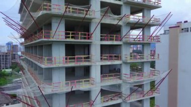Drone view of the construction site. Drone flies around the side of a multi-storey building under construction