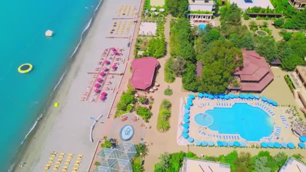 Drohnenblick Auf Einen Schönen Badeort Mit Pool Sonnenschirmen Und Türkisfarbenem — Stockvideo