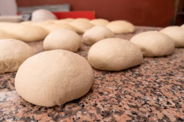Mutfak masasındaki çörek ya da diğer buğday unları için taze hamur toplarının yakın plan çekimi. Pişirmek için boş
