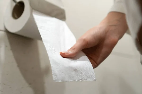 Kobieta Białym Płaszczu Siedzi Toalecie Ciągnie Papier Toaletowy Łazience Skupienie — Zdjęcie stockowe