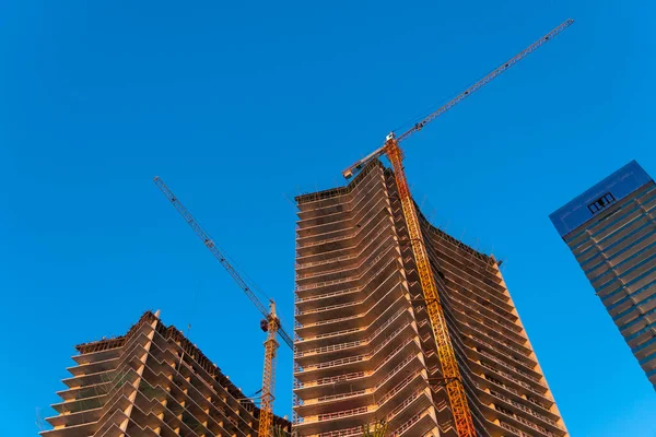 Многоэтажные Строящиеся Здания Строительными Кранами Против Голубого Неба Закате — стоковое фото