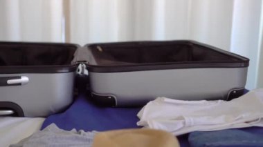 girl writes message or books accommodation using smartphone in Santa hat. She's going to resort or on vacation. suitcase and things are lying on bed. Christmas trip. hotel or room in an apartment.