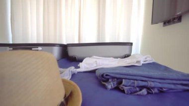 Gülümseyen genç ve güzel bir kız telefonda Noel Baba şapkasıyla konuşuyor. O bir tatil köyüne ya da tatile gidiyor. Bir bavul ve eşyalar yatağın üzerinde duruyor. Noel gezisi. Bir otel ya da dairede bir oda..