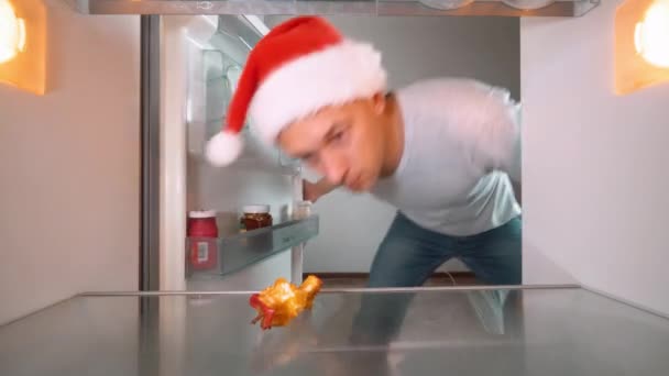 Young Man Santa Claus Hat Opens Refrigerator Party Looks Apple — Stock video