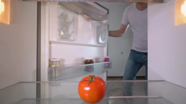 Young Man Santa Claus Hat Opens Refrigerator Party Looks Tomato — Vídeos de Stock