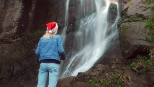 Young Blonde Santa Claus Hat Stands Makhuntseti Waterfall Georgia Female — Vídeo de Stock