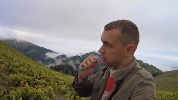 Young Man Brushes His Teeth While Standing Outdoors Hill Mountains — Vídeos de Stock