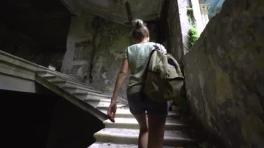 Young beautiful tourist woman walks through abandoned building, Santaroia Medea in City of Tskaltubo. Tourist place in Georgia. Abandoned places and old buildings of USSR.