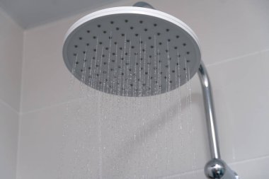 Close up rain shower with running water in a bright bathroom