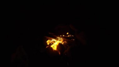 Burning fire at night. Strong wind fanns flames and almost extinguishes fire. Burning fire on cold windy night.