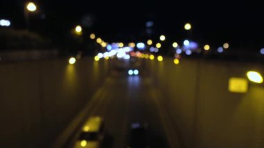 Night traffic, cars on highway in evening at night in busy city, view of city. Georgia, Tbilisi. Cars descend into tunnel, view from above.