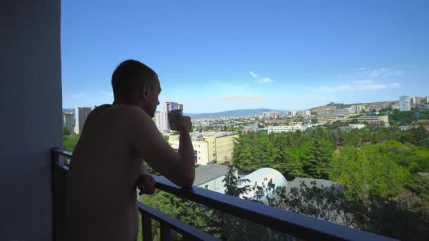 Dreamy European Man Stands Balcony Magnificent View City Drinks Hot — Stockvideo