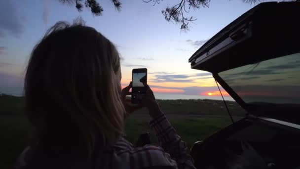 Woman Holds Mobile Phone Sunset Takes Pictures Sun Setting Horizon — Stock Video