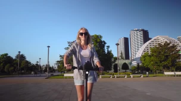 Young Beautiful Girl Rides Electric Scooter Summer Street Background City — Stock video