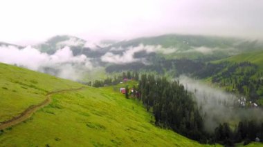 Mountains in clouds spread on ground. View from height of drone above clouds of mountain village of Bakhmaro in Georgia. high-altitude village in clouds at dawn. Beautiful mountain landscape
