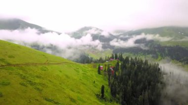 Mountains in clouds spread on ground. View from height of drone above clouds of mountain village of Bakhmaro in Georgia. high-altitude village in clouds at dawn. Beautiful mountain landscape
