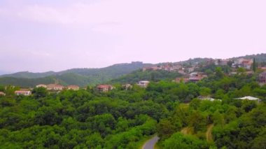 Aerial view of houses in town of Sighnaghi, eastern Georgia Scenic spring view from drone village of Sighnaghi with narrow winding streets located on hill in foothills of Gombori Range, Georgia