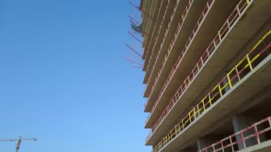 With Close-up of construction site and building. Shooting drone, it flies around only building under construction from side and shows all its floors without windows and walls. Real estate developer.