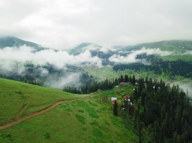 Beautiful drone view of the village in the mountains, clouds over the village. Stunning mountain landscape in the mountains with clouds on a summer day. Bakhmaro, Georgia