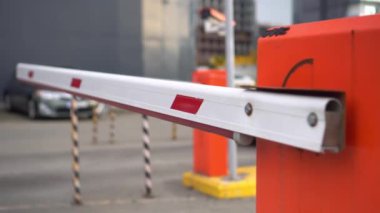 Barrier is raised and car enters parking lot. Security system for access to building - with paid cabin, and video surveillance system. Barrier on car parking. Automatic security of territory of building or house.