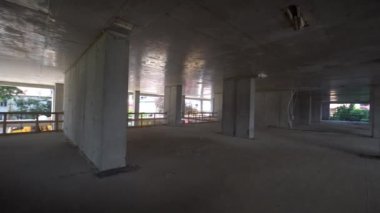 Camera moves around construction site of high building with view of city on sunny day. Apartment building under construction. Developer, real estate investment. concrete monolithic piles.