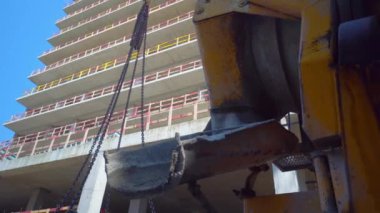 Mixer truck is transport cement to casting place on building site, Selective focus. Concrete is poured into container for transportation by crane to upper floors.