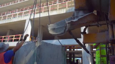Batumi, Georgia - 2 may 2022: Mixer truck is transport cement to casting place on building site, Selective focus. Concrete is poured into container for transportation by crane to upper floors.