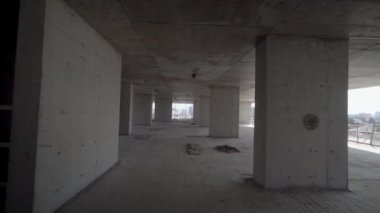 Camera moves around construction site of high building with view of city on sunny day. Apartment building under construction. Developer, real estate investment. concrete monolithic piles.